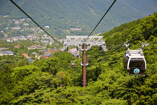 Passengers enjoying a scenic cable car ride overlooking Jammu city.