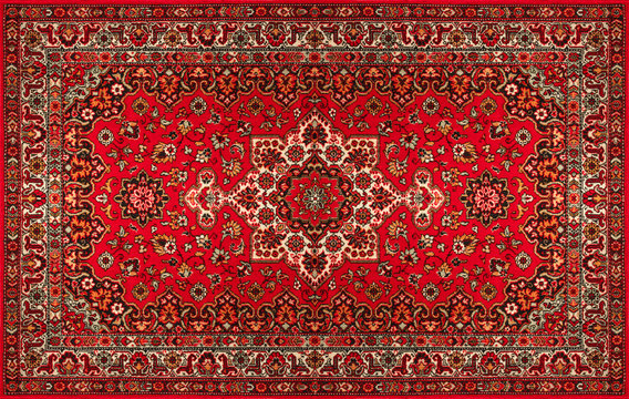 A weaver at a loom creating an ornate Kashmiri carpet or rug.