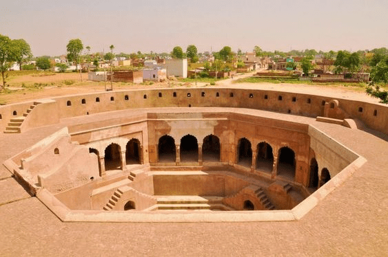 Historic stepwell Baoli Ghaus Ali Shah featuring ancient architecture and reflective water.