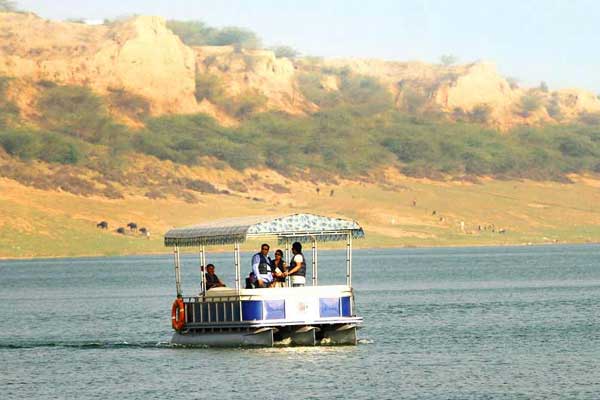 Peaceful boat ride on the Chambal River in Kota with the City Palace visible on the banks.