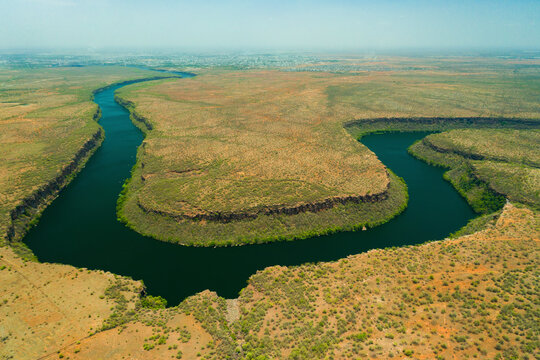 The calm waters of Chambal River winding through rocky ravines near Kota, reflecting the blue sky.