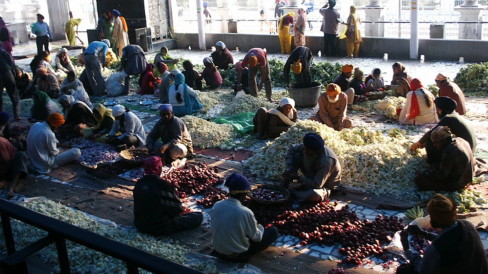 A large gathering sharing a meal in the Community Kitchen (Langar).