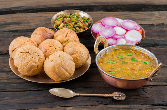 Traditional Dal Baati Churma platter with lentil curry, golden baatis, and sweet crumbled churma.