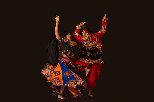 Dancers in colorful costumes performing Garba & Dandiya Raas.