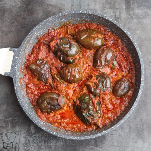 Stuffed brinjal curry Gutti Vankaya Kura garnished with fresh curry leaves.