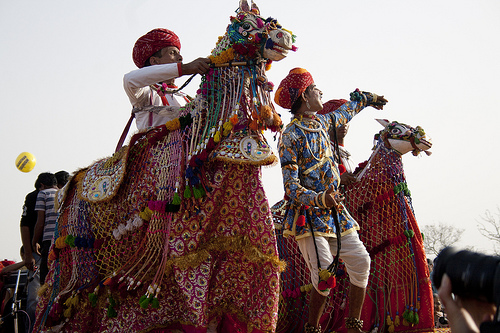 Performers dressed as horse riders enacting the Kachhi Ghodi folk dance in Kota, wielding swords with energy.