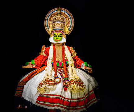 Kathakali dancer with green makeup performing a dramatic gesture.
