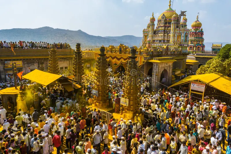 Devotees covered in yellow turmeric powder during the Khandoba festival at Jejuri.