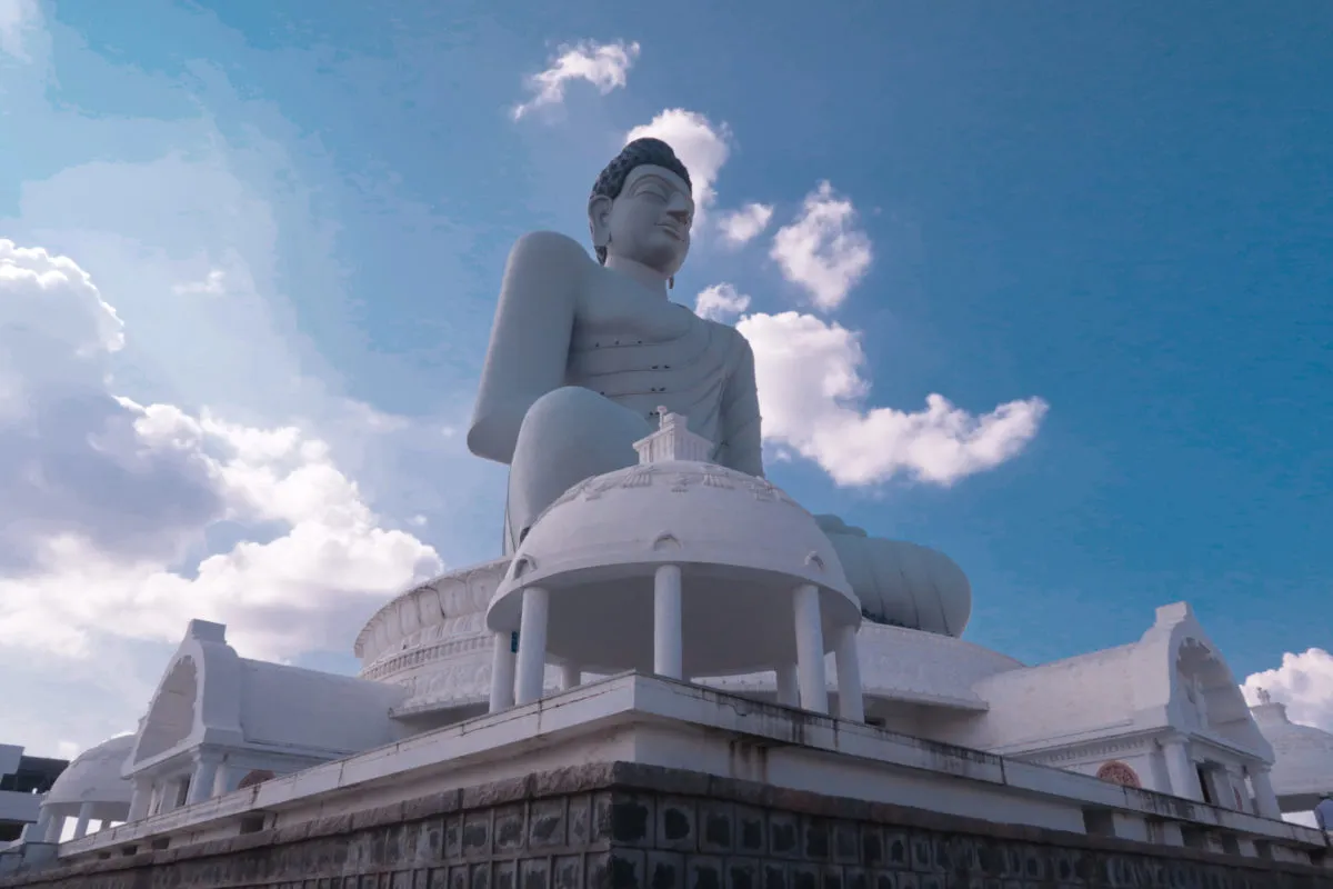 Devotee meditating in lotus pose at the Dhyana Buddha amaravati complex.