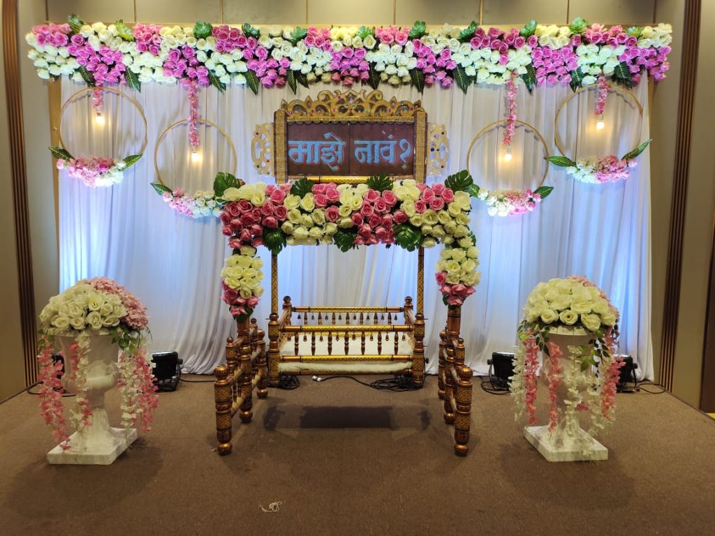 A family gathering for the Namakaran ceremony, a foundational life event ritual of Maharashtra where the newborn's name is whispered by the father.