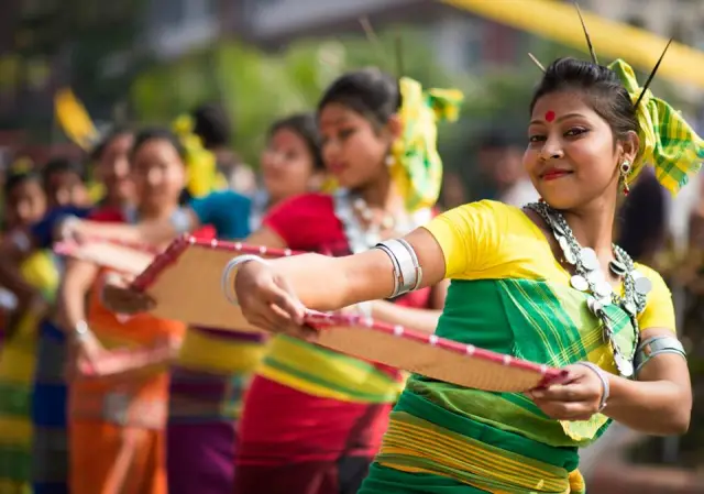 Dancers in colorful costumes performing Rajbanshi folk dance.