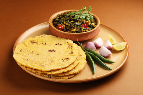 A wholesome meal of Sarson da Saag (mustard greens) and Makki di Roti (cornbread), topped with white butter.
