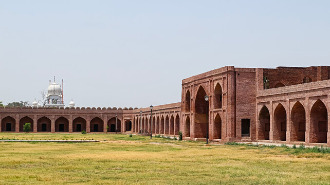 The detailed stone carvings and arched entrance of Serai Lashkari Khan, a historic rest stop.