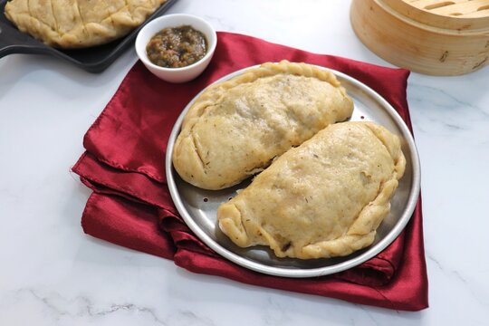 Steamed Siddu bread served with ghee and lentils.