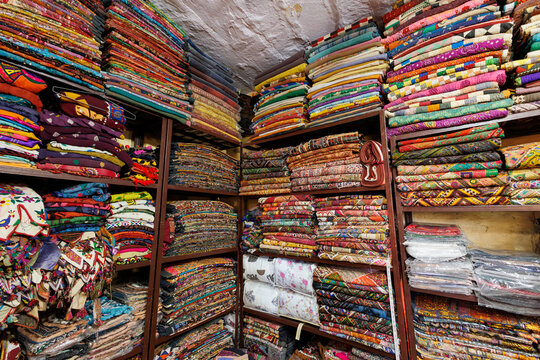 A shopper browsing colorful handloom textiles at the bustling Panipat market known for quality fabrics.