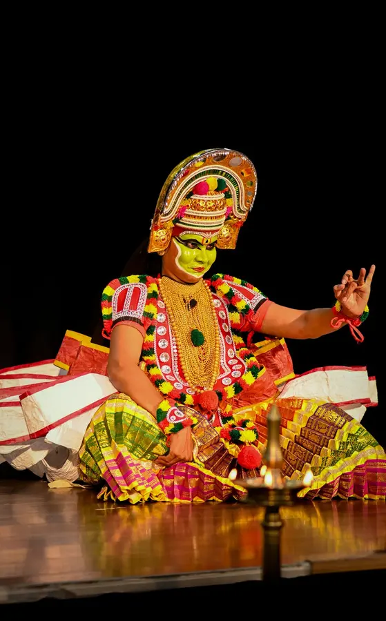 Performer in colorful attire and makeup presenting Thullal dance.