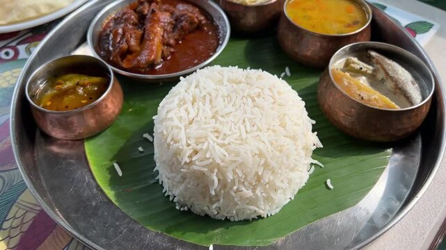 Traditional Bengali thali with rice, fish curry and vegetables.