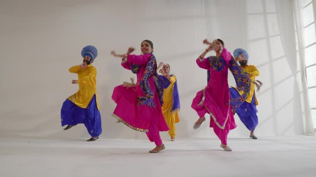 Energetic Bhangra dancers performing traditional Punjab folk dance with colorful costumes and lively moves