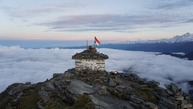 Trekkers celebrating at Chandrashila Summit with stunning Himalayan peaks visible from Chopta.
