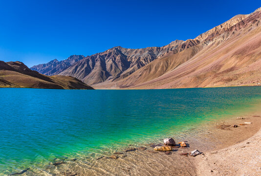 Crescent-shaped Chandratal Lake with clear blue water, a high-altitude gem in Lahaul and Spiti.