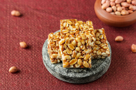 Close-up shot of crunchy peanut chikki bars stacked together, a popular sweet snack from Maharashtra.