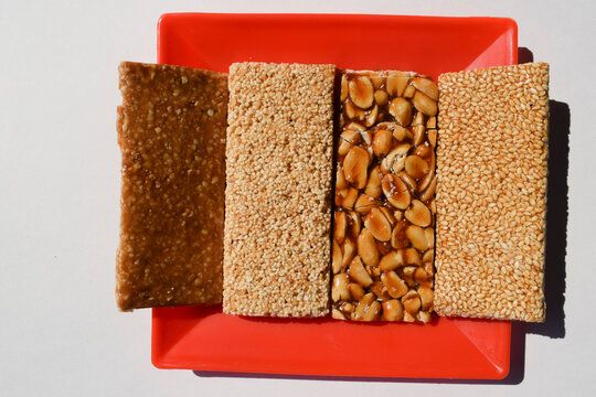 A close-up of crunchy peanut chikki, a traditional Indian sweet made from jaggery and nuts.