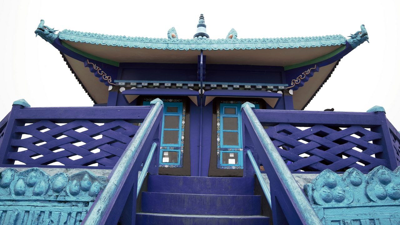 Buddhist monastery on hilltop with prayer flags offering panoramic valley views, one of the top places to visit Kalimpong for spiritual seekers