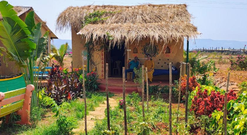 Paragliders soaring over Kamshet's green valleys and tranquil blue lakes.