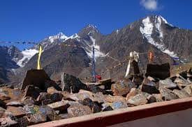 – Colorful prayer flags fluttering at Kunzum Pass, a gateway to places to visit in Lahaul and Spiti.