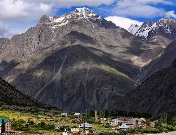 Greener landscape of the Lahaul Valley with blooming wildflowers.