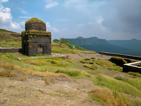 The massive stone walls of Lohagad Fort stretching along a mountain ridge, a historic fortification visible from Khandala.