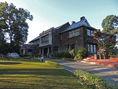 Colonial-era white bungalow with pine trees and manicured gardens, historic places to visit Kalimpong for architecture lovers