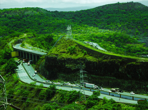 Scenic view of the Mumbai-Pune Expressway winding through the lush green hills of Khandala, a popular route for weekend getaways.