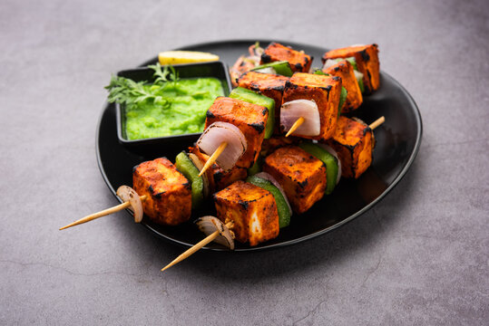Grilled Paneer Tikka skewers with colorful bell peppers and aromatic Indian spices