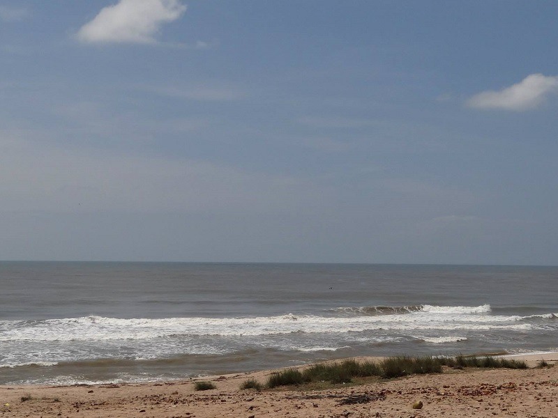 Porbandar Beach shoreline with views of Sudama Temple and local visitors enjoying evening strolls