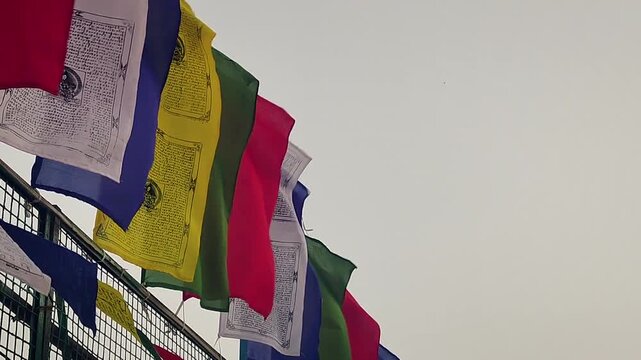 Colorful Tibetan prayer flags strung across a high mountain pass.