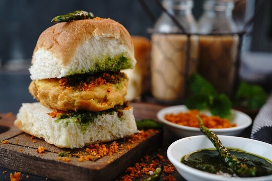 A crispy fried vada (potato fritter) sandwiched inside a soft pav bun, served with spicy green chutney.