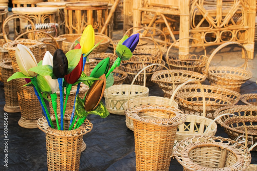 Handwoven cane stool, bamboo fish trap, and a woven hat hanging outside a Meghalaya roadside shop