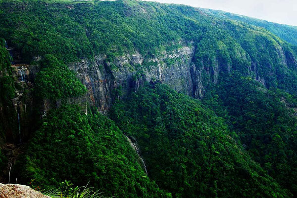 Panoramic view of rolling Jaintia Hills covered in mist and pine trees, a scenic Places to Visit in Dawki for sunrise viewing
