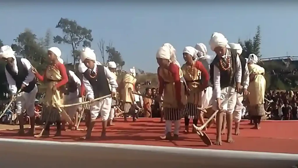 Jaintia men and women linking arms and moving rhythmically in a long line, wearing colorful striped textiles