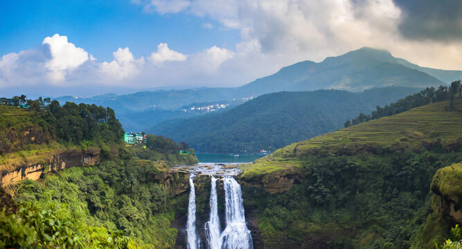 Single-drop waterfall surrounded by rocky cliffs and ferns, with a small pool at the base, near Dawki