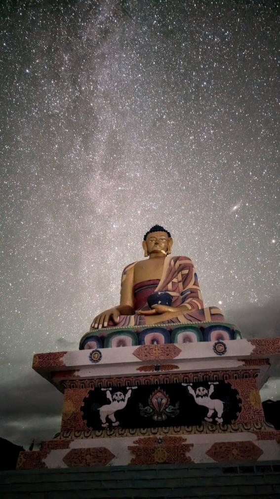 Giant Langza Buddha statue silhouetted against a breathtaking Milky Way galaxy night sky in the high-altitude village of Langza, Spiti Valley