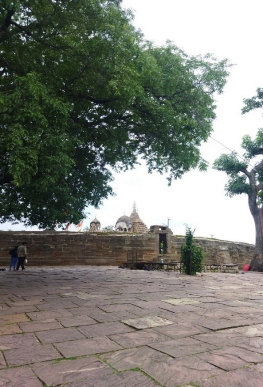 Chausath Yogini Temple complex seen from the hilltop courtyard through large trees, Bhedaghat, Jabalpur, Madhya Pradesh