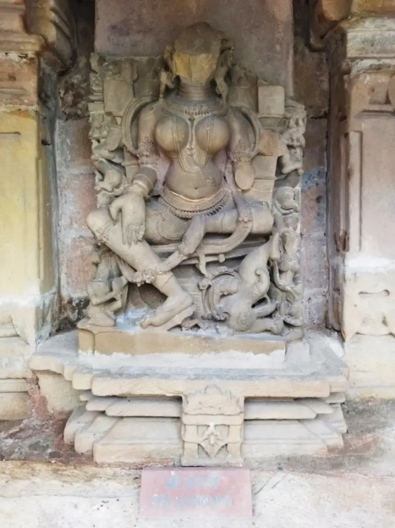 Stone sculpture of Sri Jahnavi Yogini holding a pedestaled sphere in a niche at Chausath Yogini Temple Bhedaghat with nameplate reading Sri Jahnavi