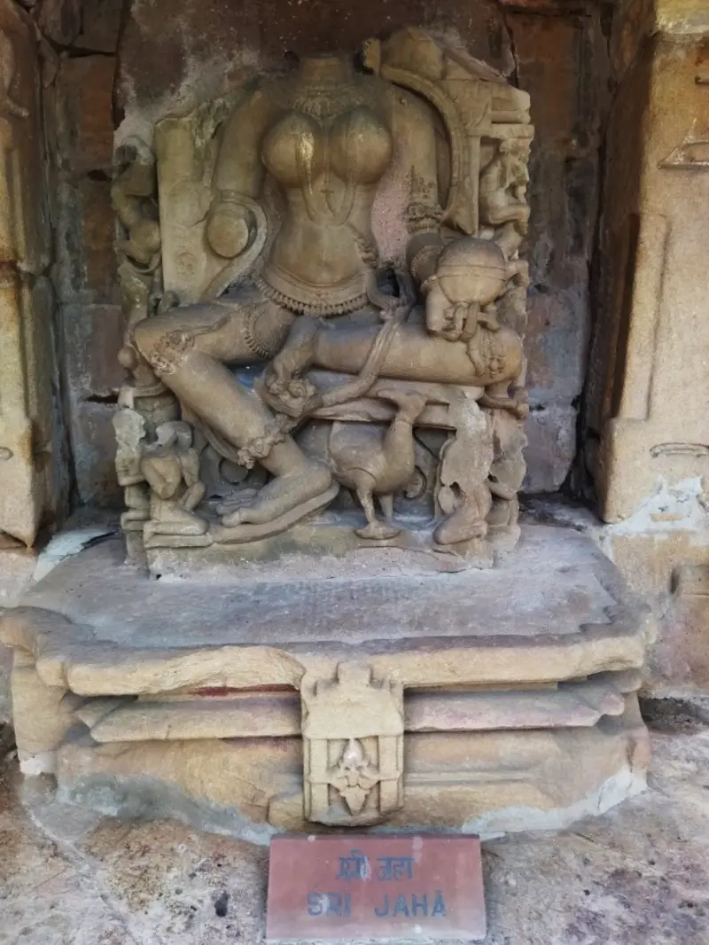 Stone sculpture of Sri Jaha Yogini holding a pedestaled sphere in a niche at Chausath Yogini Temple Bhedaghat with nameplate reading Sri Jaha